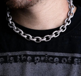 a close up of a man wearing a chain necklace