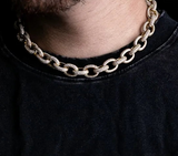 a close up of a man wearing a gold chain necklace