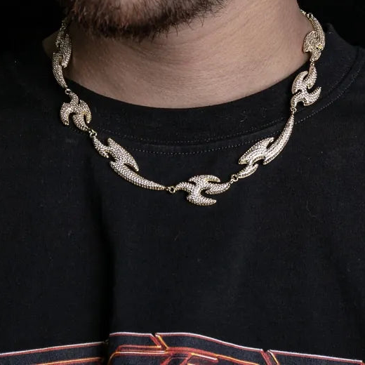 a man wearing a black shirt and a gold necklace